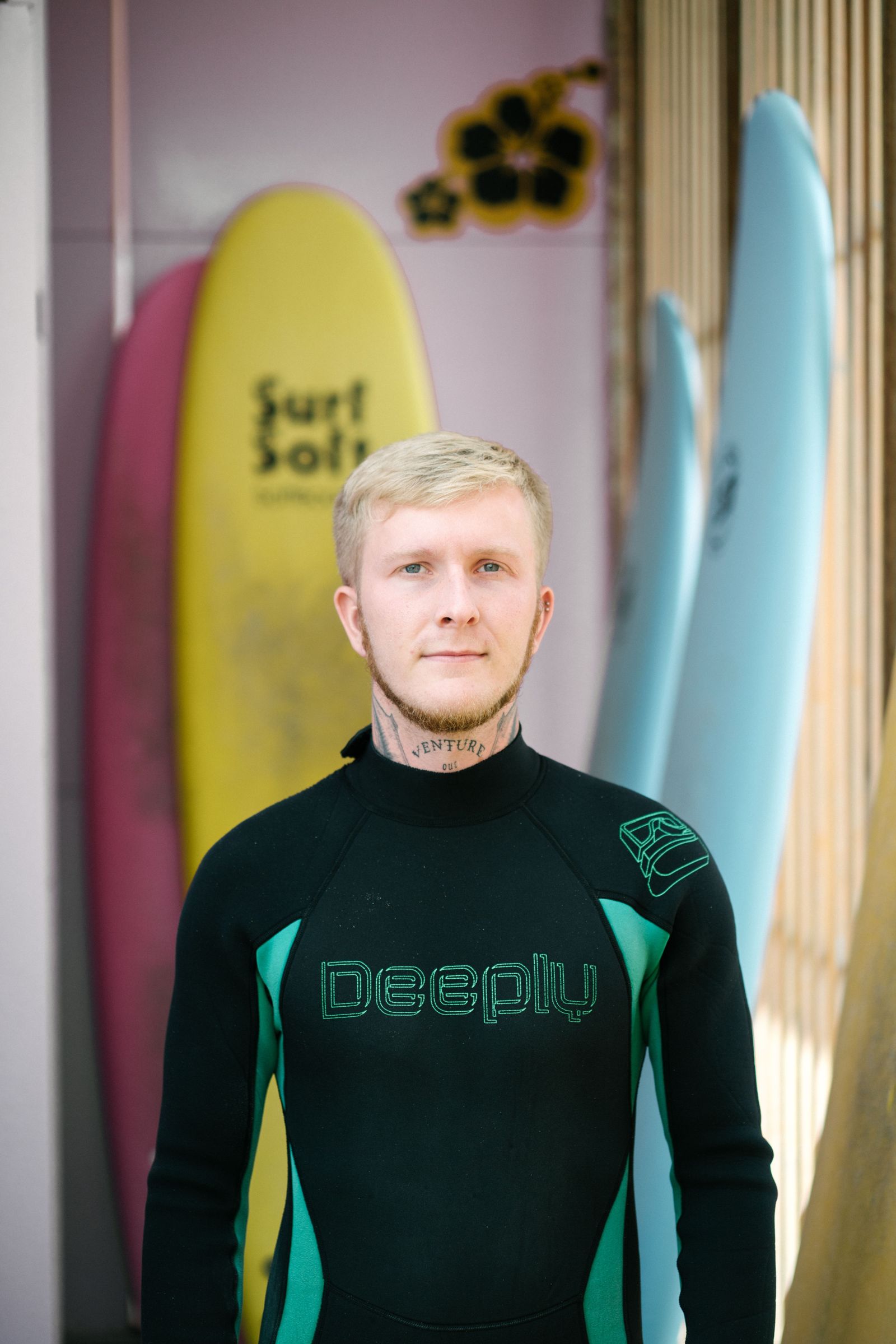 Bruno con traje de neopreno frente a las tablas de la escuela